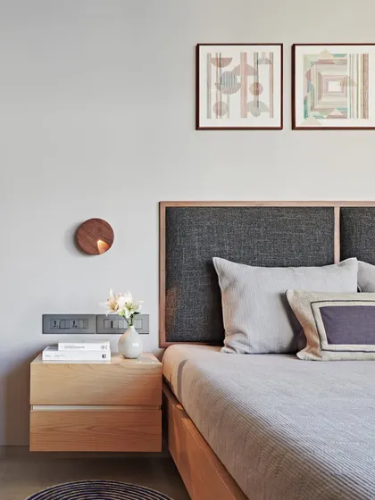 This bedroom in the Maximum City Duplex is a study in soft neutrality. The upholstered headboard, floating nightstand, and simple geometric art come together to create a calm and timeless space.