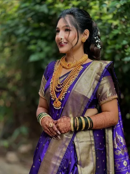 A happy bride in her purple Nauvari. The drape is designed to be flattering and comfortable, allowing her to enjoy every moment of her special day.