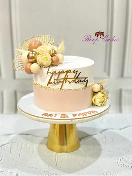 An elegant and classy birthday cake for 'Aai & Pappa', adorned with soft pastel tones, delicate roses, and golden accents.
