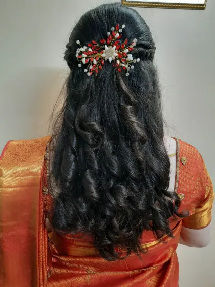 This is a great example of a modern hairstyle for a reception or pre-wedding event. I created soft, bouncy curls and a half-up twist, finished with a delicate hair accessory for an elegant and romantic feel.