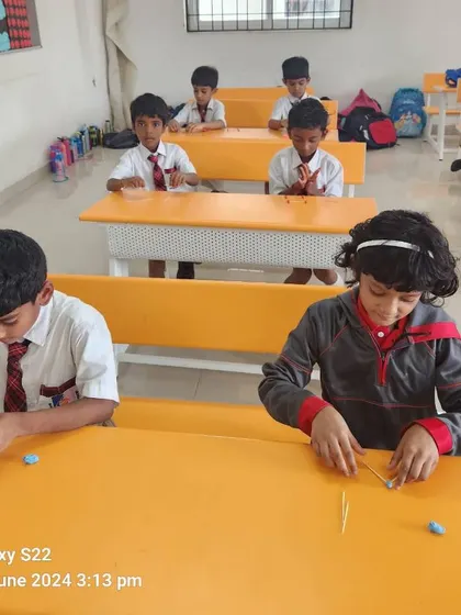 Students work diligently at their desks, using playdough and sticks to explore geometric concepts in a tangible way.