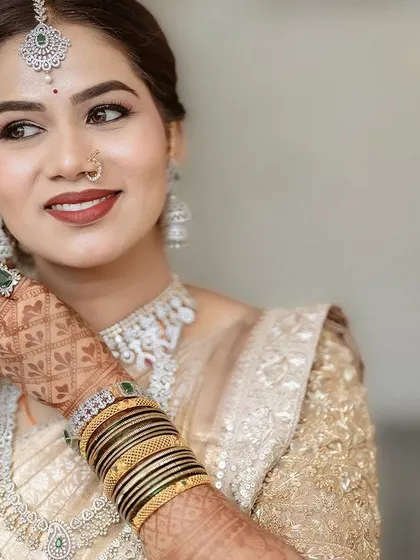 A beautiful portrait of the bride. Her makeup features a soft, glowing complexion and defined eyes, making her look effortlessly elegant.