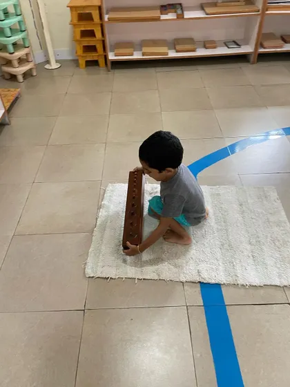 The Cylinder Blocks are a foundational sensorial material. By fitting each cylinder into its correct socket, the child refines their pincer grip for writing and develops their ability to visually discriminate between different dimensions.
