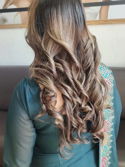 This balayage with tight curls is perfect for a party or special event, showcasing the beautiful blend of colors.
