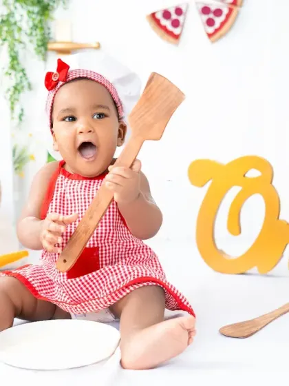 A playful moment from the little chef photoshoot, as she discovers the wooden spoon. These candid shots perfectly capture a toddler's sense of wonder and curiosity.