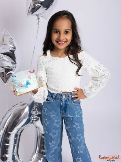 Celebrating a perfect 10! This birthday girl is all style and smiles, holding her cake in a chic and modern studio setup.