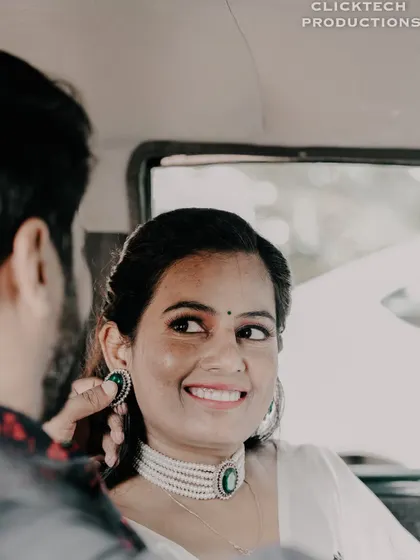 A close-up shot from the driver's seat, capturing the bride's happy expression as she looks at her partner in a vintage car.