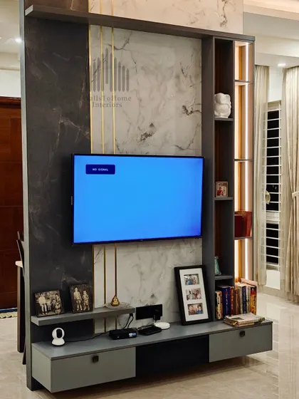 This TV unit doubles as a partition, cleverly separating spaces while maintaining an open feel. The design incorporates a mix of materials, open shelves for decor, and integrated lighting for a contemporary look.