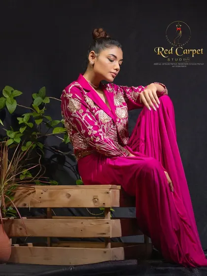 This fuchsia pink fusion outfit is all about the details. The cropped jacket is heavily embroidered with gold threadwork, creating a look that is both modern and regal.