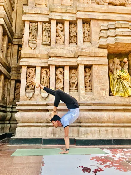 In this scorpion handstand, touching the foot to the head symbolizes enlightenment. Practicing in front of this ancient temple adds a layer of history and devotion.