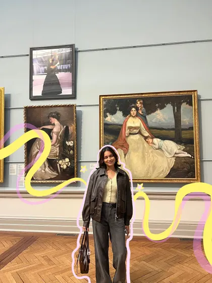 Posing with the classics. The pink and yellow doodles add a modern, playful contrast to the classical art in this museum shot.