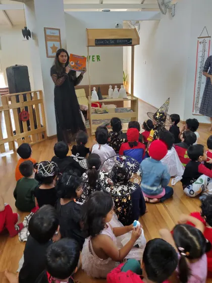 A spooky Halloween story session. The children, all dressed in their costumes, listened intently to a tale about a friendly witch.