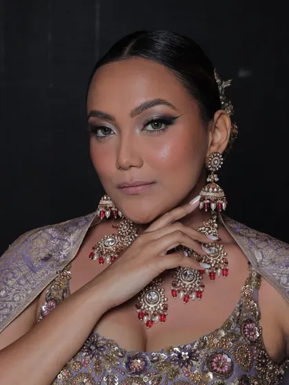 This model wears a beautiful Polki set with red bead accents, which perfectly complements her lavender-grey lehenga.