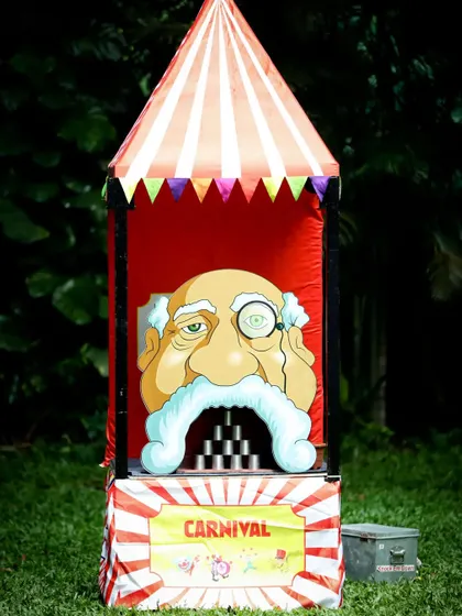 A classic 'can toss' carnival game stall, one of many activities to keep guests engaged.