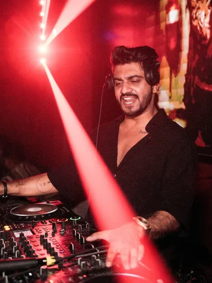 Caught in a beam of red light at Lacena. This artistic shot highlights the dramatic lighting and my focus during a set.