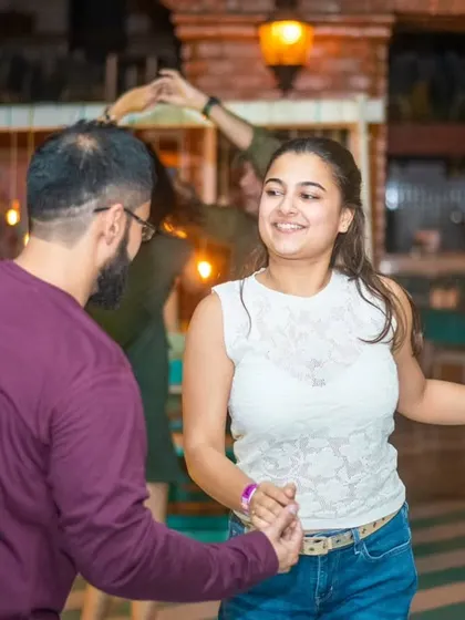 A happy and relaxed pair moving together on the dance floor. It’s a welcoming space for all.