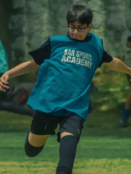 A player wearing a Sar Sportz Academy bib during a training match.