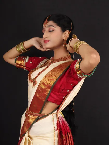 A graceful pose from the Murtham bride shoot. The soft, nude makeup look enhances her features without overpowering the simplicity of the white and red saree.
