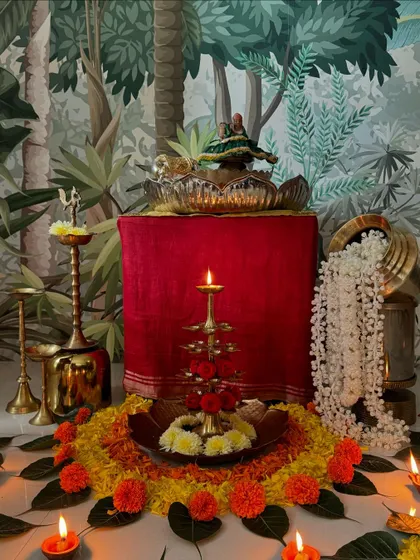 A close-up of the Janmashtami setup. The little Krishna idol, the flower arrangement, and the diyas create a divine atmosphere.