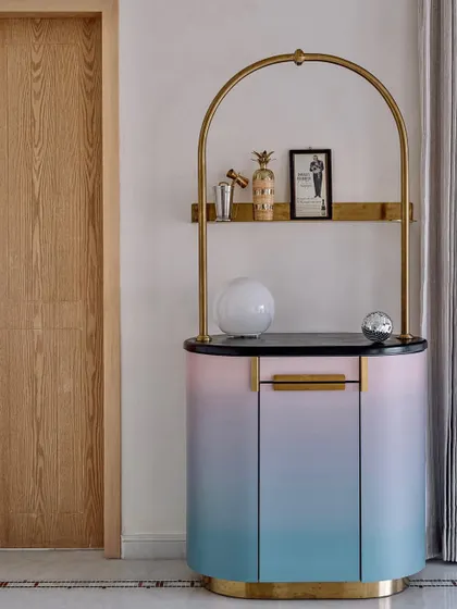 A still shot of 'The Gradient Bar' with its light off, showcasing the beautiful ombre finish and elegant brass details.