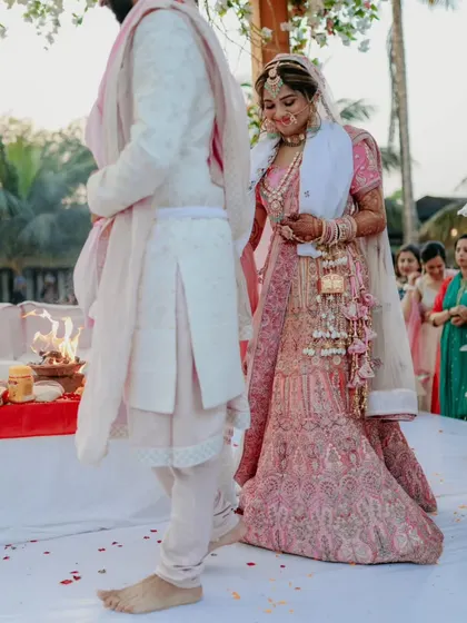 The bride follows the groom during the pheras, a traditional and significant part of the Hindu wedding ceremony.