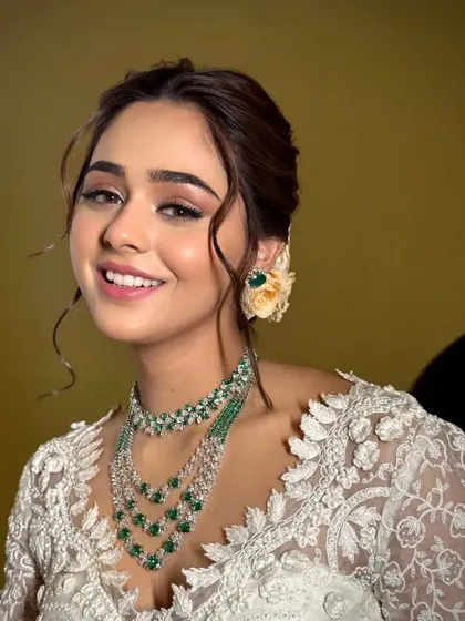A smiling bride, radiating happiness and elegance in her white lace saree.