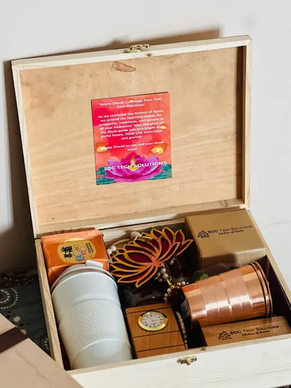 A look inside a premium Diwali hamper for a tech client. This gift includes a branded copper tumbler, a desk clock, a travel mug, and a personalized festive card, all within a custom wooden box.