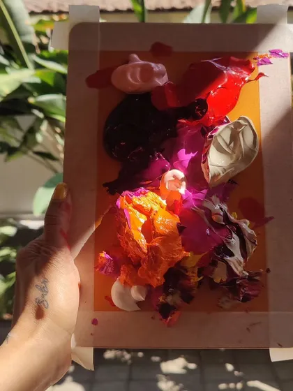 Holding up a test palette of dried, textured paint skins, a key part of our experimental process in developing new textures and color combinations.