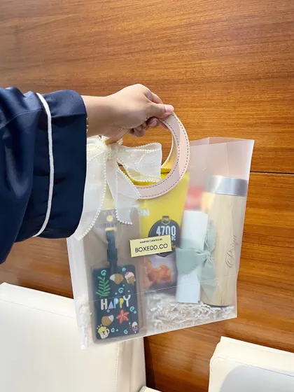 A guest holding our tropical-themed welcome bag. This shows the scale of the bag and how it serves as a convenient and stylish tote for carrying wedding goodies.