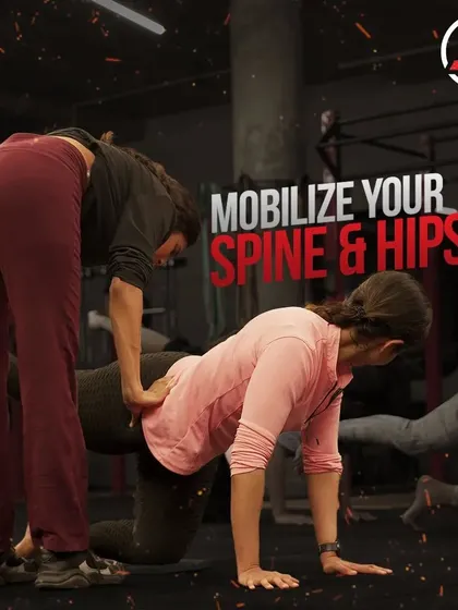 A coach providing a tactile cue during a hip mobilization drill. This hands-on approach ensures you're performing the movement correctly for maximum benefit.