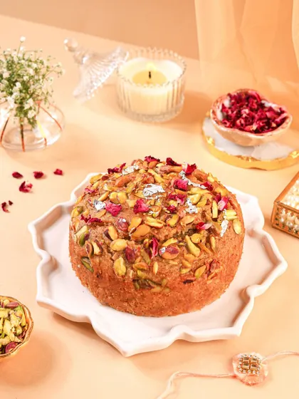 The Mawa cake styled with a candle and a rakhi, making it a perfect centerpiece for a Raksha Bandhan celebration.