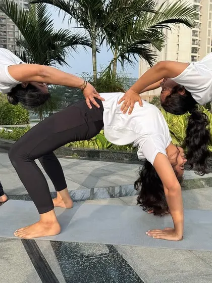 Another angle of this beautiful three-person backbend. It highlights the alignment, strength, and trust required to create such a supportive and interconnected shape.