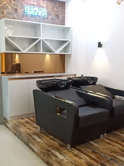 The shampoo station at the Faridabad salon, built on a raised wooden platform. We added a custom shelving unit for towels and products, along with a neon sign to create a trendy, stylish corner.