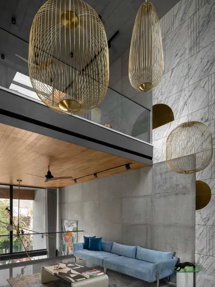 The informal living area in Swatantra Residence is a multi-level design with a beautiful blend of colors and textures. All artwork, furniture, and lighting, including these custom cage-like chandeliers, were designed to meet the family's needs.
