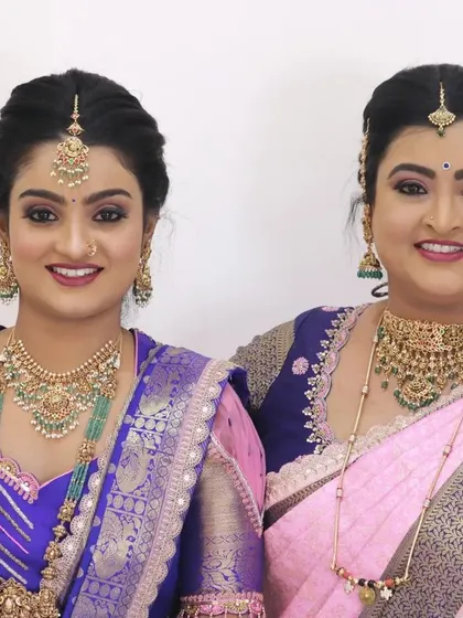 A beautiful portrait of two clients, showcasing complementary makeup looks that enhance their traditional South Indian attire.