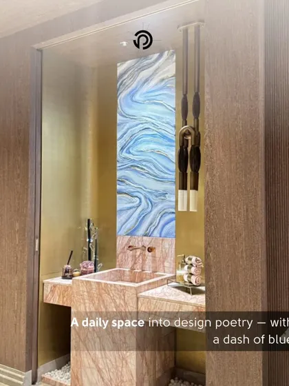 This powder room from 'The Aura House' project was designed to feel like a piece of art. A tall, vertical panel of blue and white agate-style art creates a stunning backsplash, complemented by a pink marble vanity and minimalist pendant lighting.