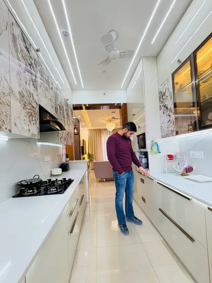 A final check of a stunning parallel kitchen. This design features white cabinets with a marble-patterned laminate on top, creating a luxurious and cohesive look. The long handles add a touch of modern elegance.