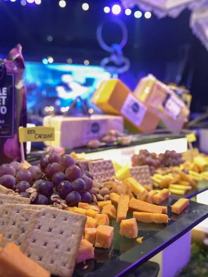 An abundant cheese and cracker spread, featuring a variety of international and local cheeses, grapes, nuts, and crackers. This is a classic and sophisticated addition to any corporate cocktail event.