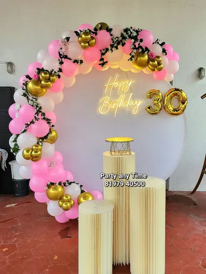 A pretty pink, white, and gold balloon arch for a 30th birthday celebration.