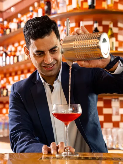 Varun Sharma, our award-winning mixologist, crafting one of his signature cocktails with a smile.