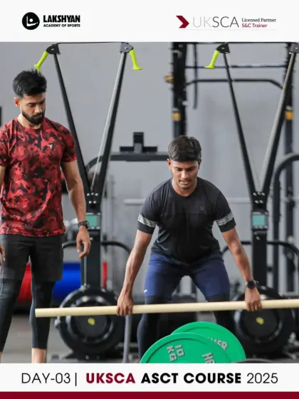 A coach demonstrates the correct setup for a barbell lift, emphasizing grip and posture as part of the strength training module on Day 3.