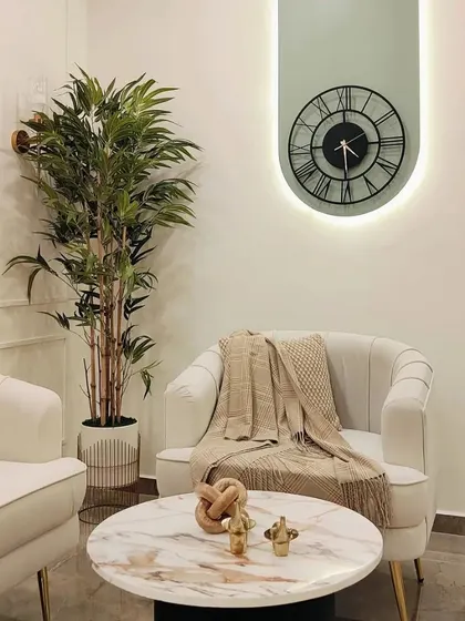 Understated luxury in a quiet corner. This beautifully curated space celebrates simplicity, where a comfortable armchair, a marble coffee table, and soft throws invite relaxation.