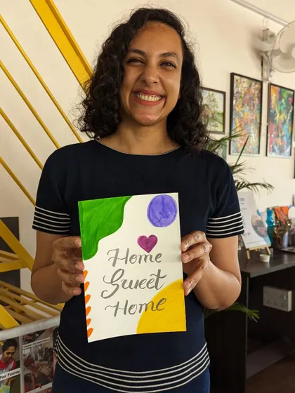 A participant with her finished calligraphy card, a beautiful piece of hand-lettered art.