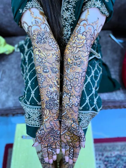 Another view of Saima's bridal henna, showing the full design against her elegant green dress.