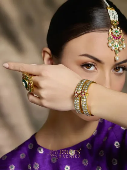 From head to hand, let Aalayaa weave its magic. This model showcases a maang tikka, a statement ring, and delicate polki bangles.