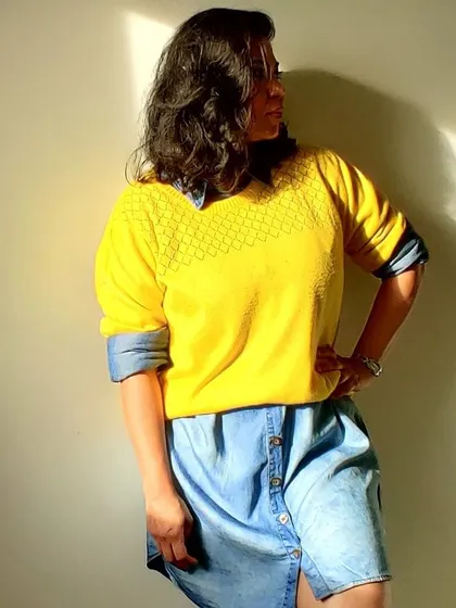 To make a relaxed-fit outfit more interesting, I love layering it with a piece in a contrasting color. Here, I've paired a denim shirt dress with a bright yellow sweater for a fun and casual look.