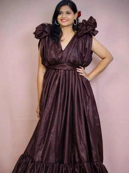 A closer look at the "Slaying Browny" gown. The structured shoulders and flowing fabric create a powerful and elegant silhouette.