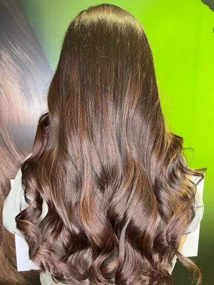 The stunning "after" result. A deep base melts into beautiful wine red ends, styled with voluminous waves.