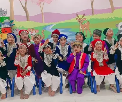 The complete group of New Horizon Kids in their traditional Kashmiri outfits, showing the vibrant mix of colors and detailed embroidery in each costume.