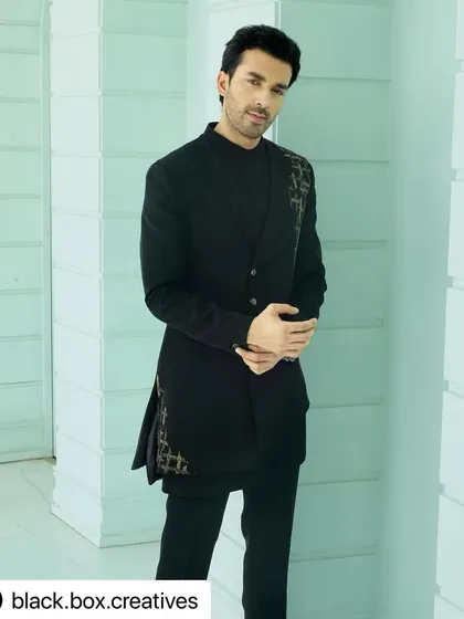 A modern and stylish look for an editorial shoot. The grooming is minimal and masculine, focusing on flawless skin and perfectly styled hair to complement the Indo-western outfit.